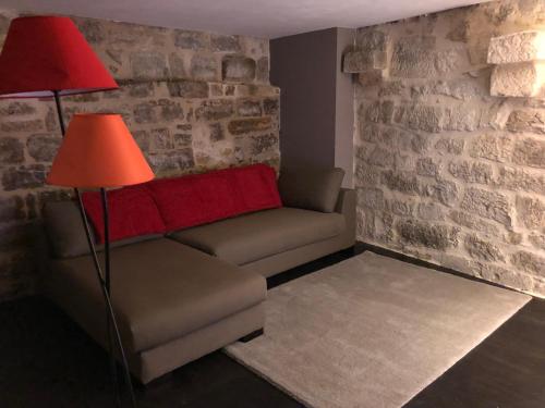 a living room with a couch and two lamps at Les Maisons du Périgord in Terrasson-Lavilledieu