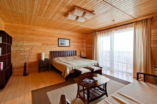 1 dormitorio con 1 cama en una habitación de madera en Zolotaya Buhta Hotel, en Anapa