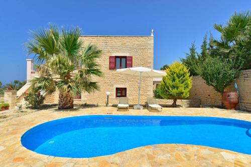 a villa with a swimming pool in front of a house at Grecian Villas Chania in Delimanolianá