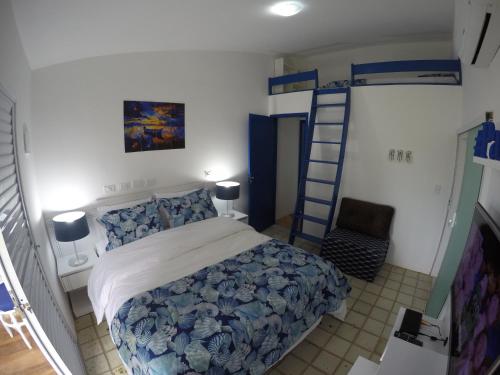 a bedroom with a bed and a ladder to a bunk bed at Village Galés Maragogi - Chalé 03 in Maragogi
