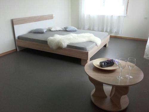 una camera con letto e tavolo con bicchieri da vino di Brīvdienu māja 1 a Kurmēni