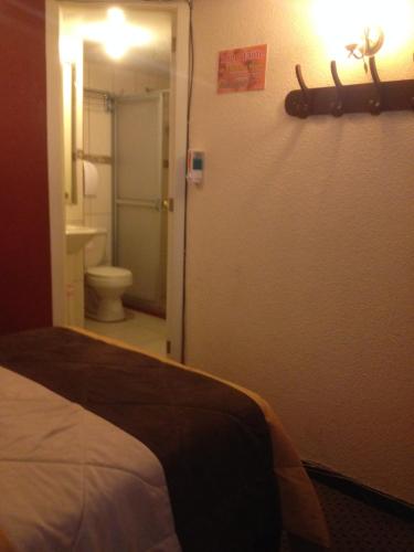 a bedroom with a door to a bathroom with a toilet at Samana Hostal in Otavalo