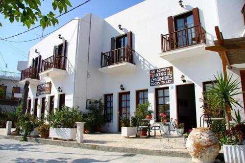 a white building with balconies and a table in front of it at Lykomides in Skiros