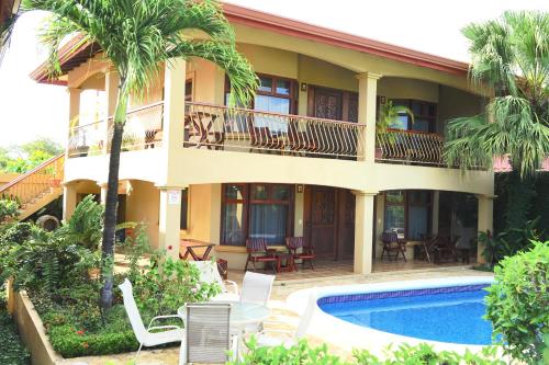 a house with a swimming pool and a resort at Villas Welcome to Heaven in Carrillo