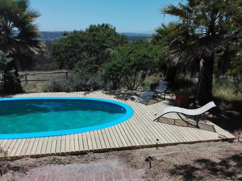 una piscina con una terraza de madera y una silla blanca en Casa San Juan, en San Juan
