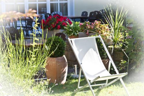a white chair sitting in a yard with plants at Der Stasta in Vienna