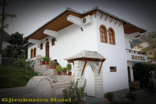 a small white building with a roof at Hotel Gjirokastra in Gjirokastër