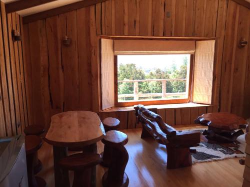 a living room with a table and a window at Terrazas altos de Gamboa in Castro