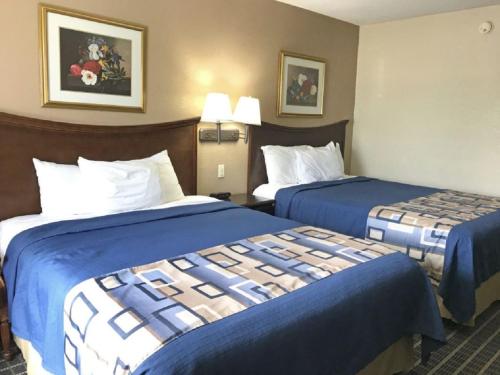 a hotel room with two beds with blue sheets at Americas Best Value Inn Mount Vernon in Mount Vernon
