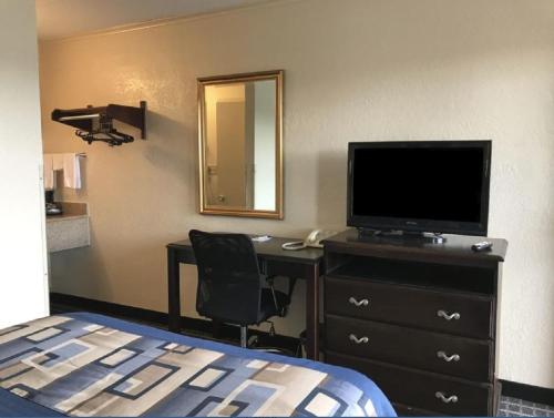 - une chambre avec un lit et un bureau avec une télévision dans l'établissement Americas Best Value Inn Mount Vernon, à Mount Vernon