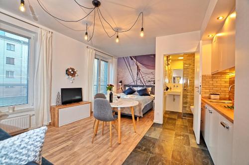 Tartaczna Deluxe Apartments Gdansk في غدانسك: غرفة معيشة وغرفة نوم مع سرير وطاولة