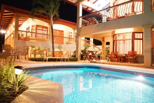 a swimming pool in front of a house at night at Villas Welcome to Heaven in Carrillo