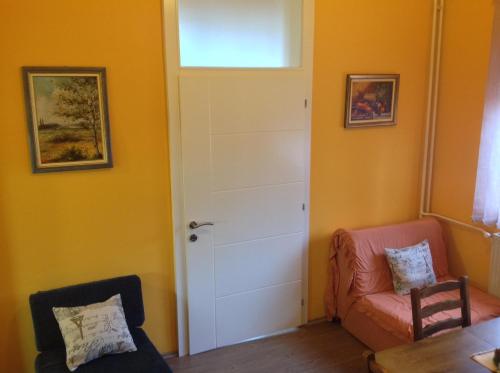 a living room with a door and a chair at Apartments Villa Svetlana in Vrnjačka Banja