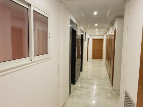 a corridor in a building with white walls and tile floors at Appartement S+1 Jardin De Carthage in Tunis