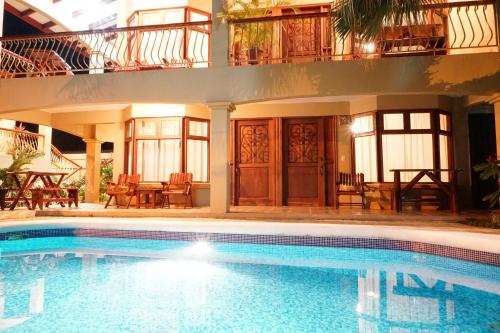 a swimming pool in front of a house at Villas Welcome to Heaven in Carrillo