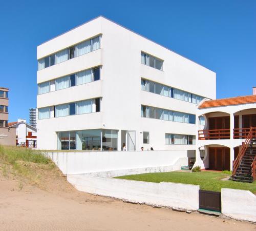 un edificio blanco junto a una playa del hotel Vista de Villa Gesell