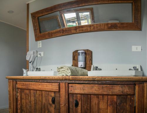 a bathroom vanity with two sinks and a mirror at Puma House in Puerto Natales
