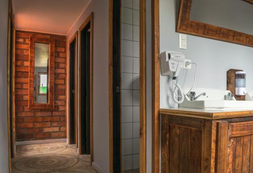 y baño con lavabo y espejo. en Puma House en Puerto Natales