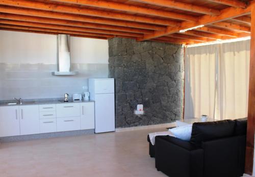 a living room with a black couch and a white refrigerator at Las Arecas Loft in Playa Blanca