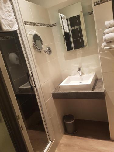 a bathroom with a sink and a shower at Logis - Hôtel du Nord et Restaurant La Table d'Elisa in Compiègne