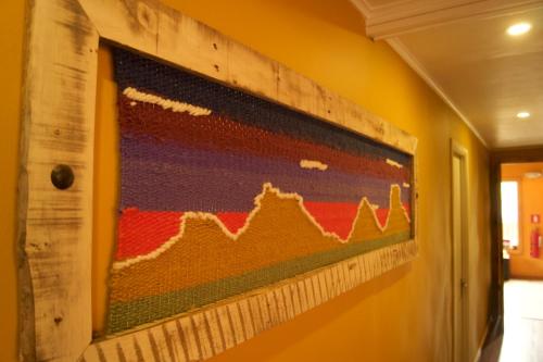 a painting hanging on a wall in a hallway at Puma House in Puerto Natales
