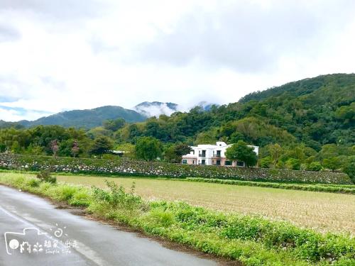 a house on the side of a road next to a field at Simple Life in Yuli