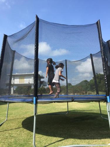 two children are playing on a trampoline at guest house annsea in Ishigaki Island