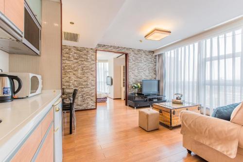 a kitchen and living room with a couch and a tv at Westlake 7 Service Apartment in Hangzhou