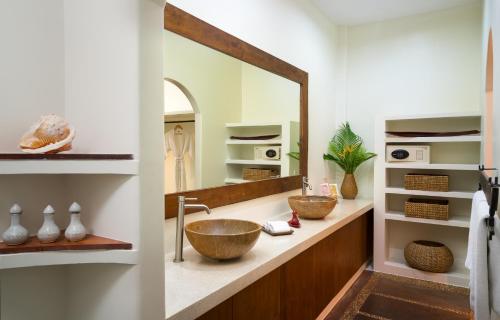 a bathroom with a sink and a large mirror at Navutu Dreams Resort & Wellness Retreat in Siem Reap