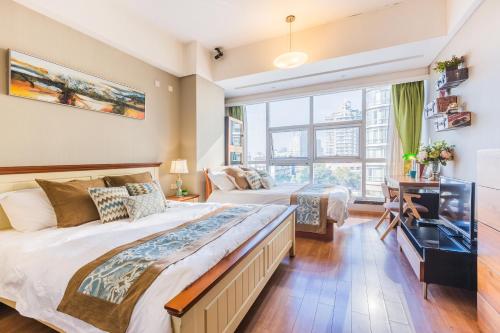 a bedroom with two beds and a television at Westlake 7 Service Apartment in Hangzhou