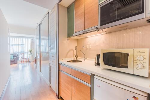 a kitchen with a microwave and a sink at Westlake 7 Service Apartment in Hangzhou