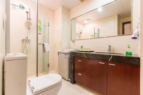 a bathroom with a toilet and a sink and a mirror at Westlake 7 Service Apartment in Hangzhou