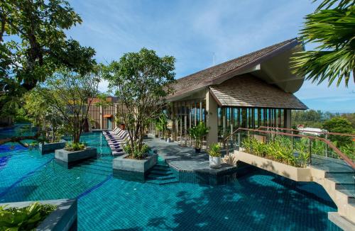 an exterior view of a resort with trees and blue water at Mandarava Resort and Spa, Karon Beach - SHA Extra Plus in Karon Beach