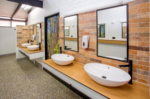 a bathroom with three sinks and two mirrors at BIG4 Yarra Valley Park Lane Holiday Park in Healesville