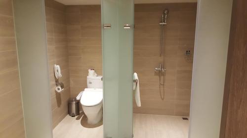 a bathroom with a toilet and a shower with a phone at Chiayi Maison de Chine Hotel in Chiayi City
