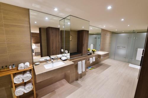 ein Badezimmer mit einem Waschbecken und einem großen Spiegel in der Unterkunft Chiayi Maison de Chine Hotel in Chiayi