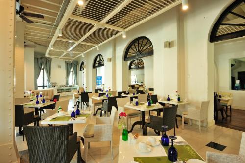 a restaurant with tables and chairs in a room at Royale Chulan Penang in George Town