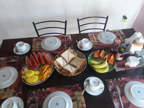 una mesa con platos de comida y fruta. en Lilly Palace Villa Guest House, en Negombo