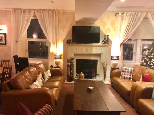 a living room filled with furniture and a fire place at The Arrandale Hotel in Ayr