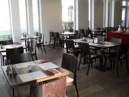 jadalnia ze stołami, krzesłami i oknami w obiekcie Art Hotel Podebrady w Podiebradach