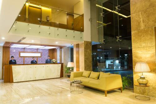 a lobby with a yellow couch and a bar at Classic Grande,a Member of Radisson in Imphal