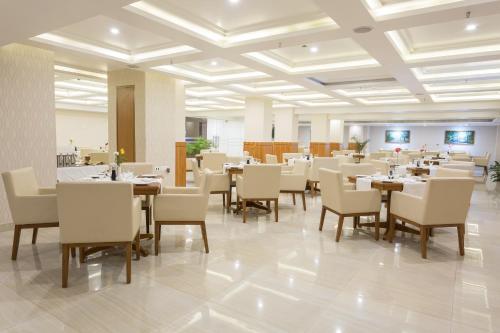 a restaurant with tables and chairs in a room at Classic Grande,a Member of Radisson in Imphal