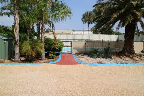 a red and blue path in a park with palm trees at Renmark Motor Inn in Renmark