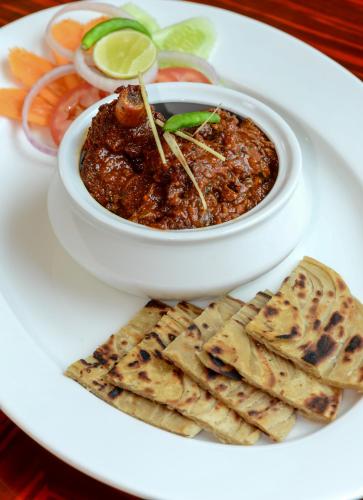 a plate of food with a bowl of chili and crackers at Howard Johnson by Wyndham, Kolkata Airport in Kolkata