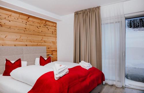 a bedroom with a large bed with red and white pillows at Appartements Almnest in Schladming