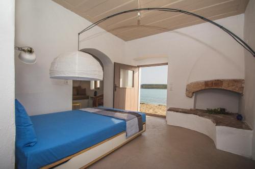 a bedroom with a bed and a view of the ocean at Donusa Beach House - Etheras properties in Diakofti