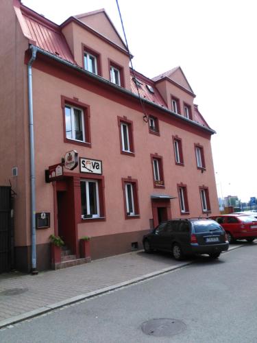 a red building with a car parked in front of it at Apartment Sova in Ostrava