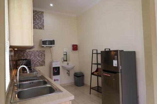 a kitchen with a sink and a refrigerator at Diyar Villas Puncak M6/14 in Puncak
