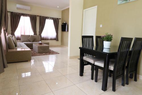 a living room with a table and chairs and a couch at Diyar Villas Puncak M6/14 in Puncak