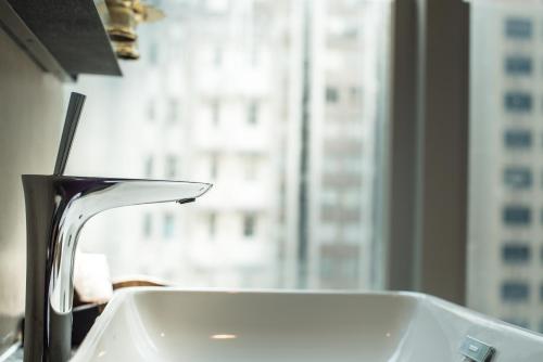 a bathroom sink with a view of a window at Soravit on Granville in Hong Kong